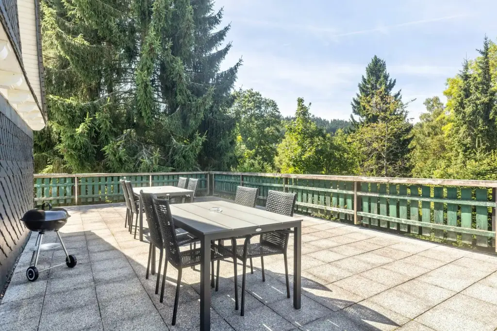 Dachterrasse mit Sitzgruppe, Holzkohlegrill und Blick auf den Wald