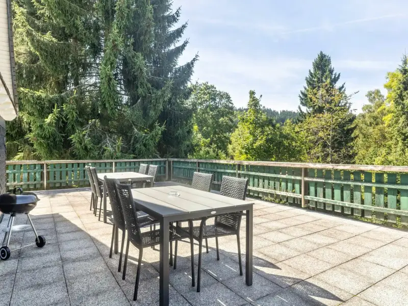 Dachterrasse mit Sitzgruppe, Holzkohlegrill und Blick auf den Wald
