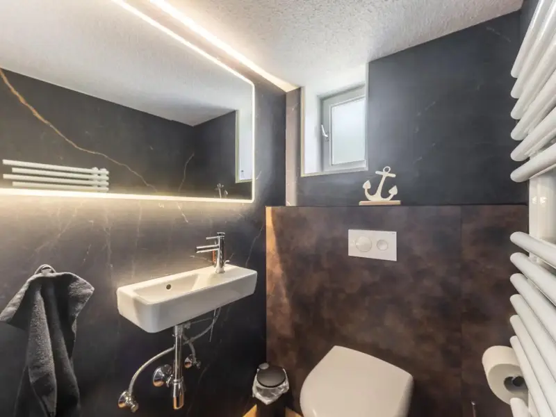 Separates Gäste-WC mit dunklem Wanddekor, Ferienwohnung Bödefeld