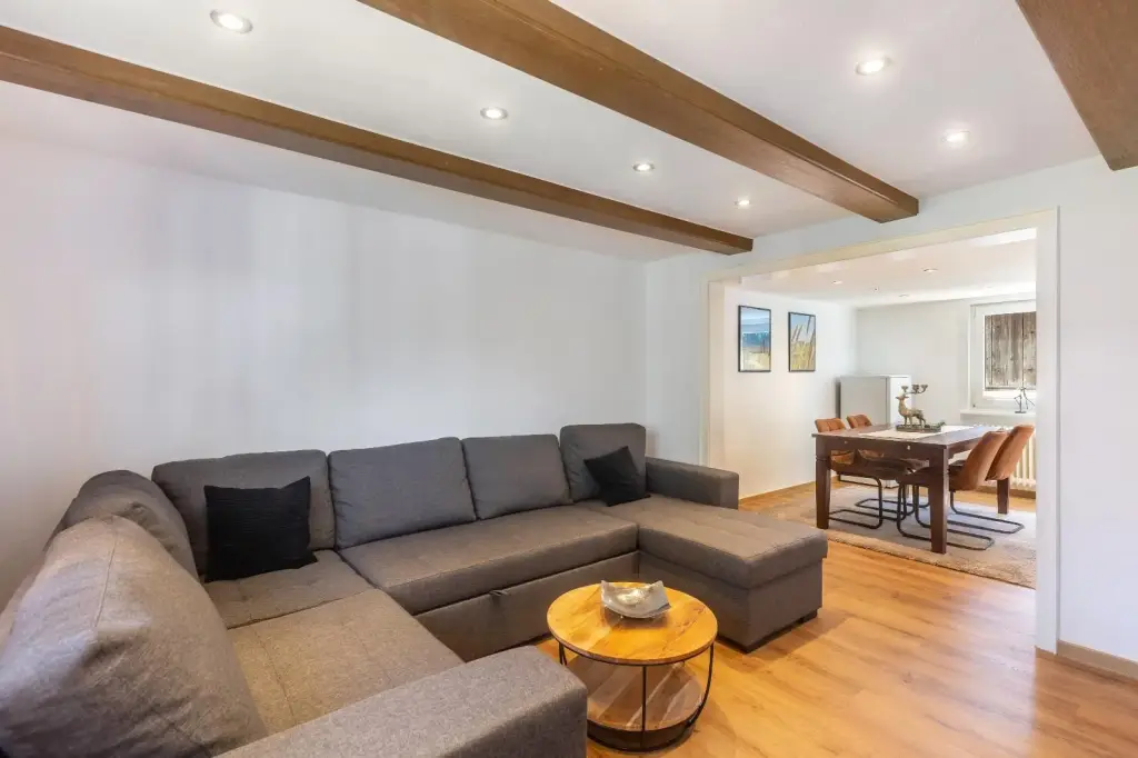 Wohnbereich mit Eckcouch und Blick in den Essbereich, Deluxe Apartment