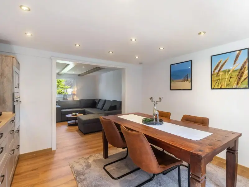 Offener Wohn- und Essbereich mit Holztisch und Blick in die Küche, Ferienwohnung Bödefeld