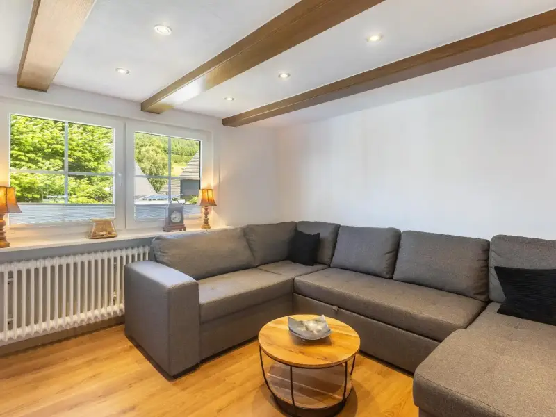 Wohnzimmer mit Eckcouch und Blick ins Grüne, Ferienwohnung Bödefeld
