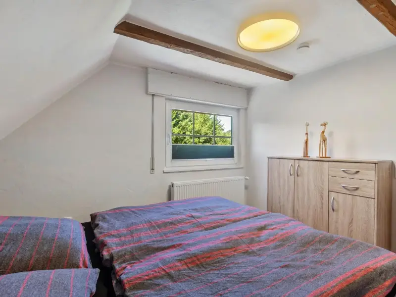 Schlafzimmer mit Kommode und Fensterblick ins Grüne, Ferienwohnung Gellinghausen