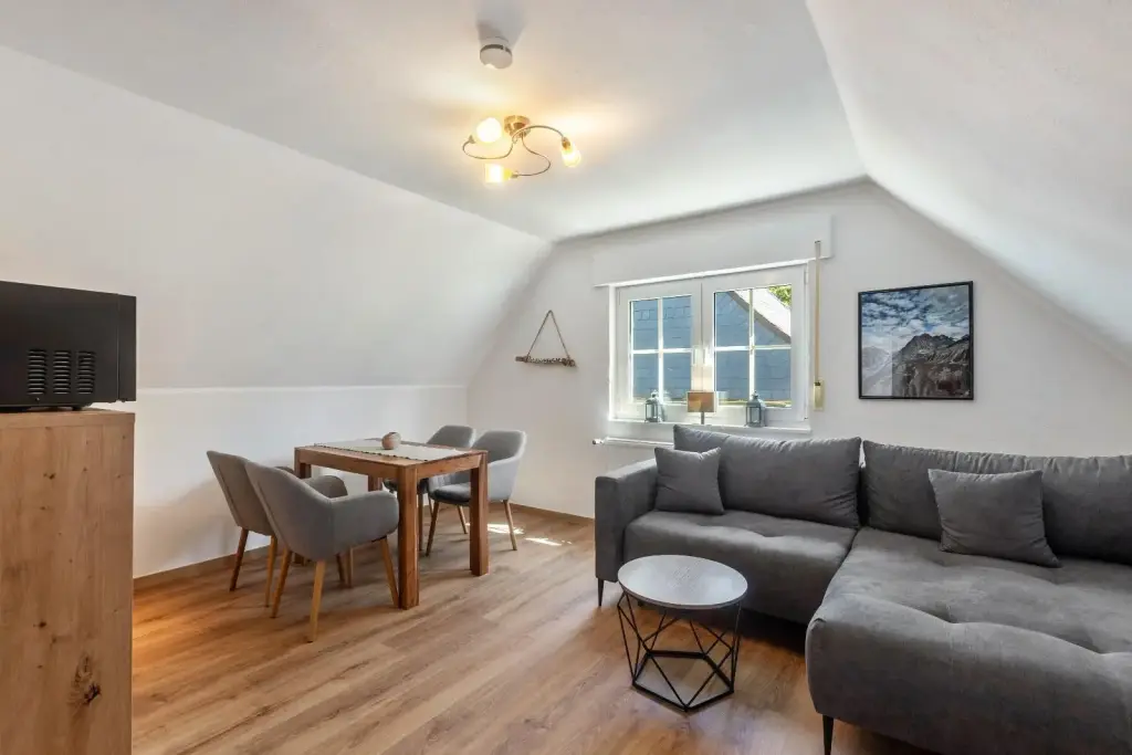 Wohn- und Essbereich mit Sofa und Esstisch unter der Dachschräge, Superior Apartment