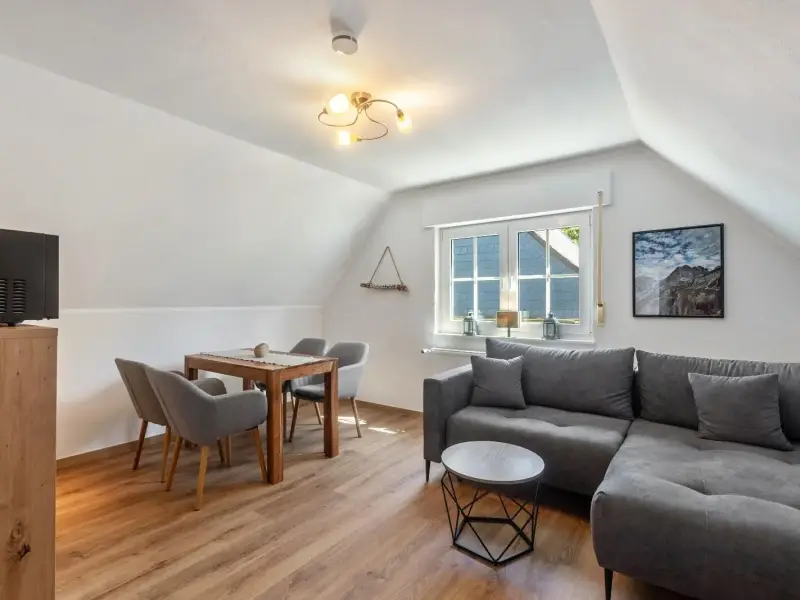 Wohn- und Essbereich mit Sofa und Esstisch unter der Dachschräge, Ferienwohnung Gellinghausen
