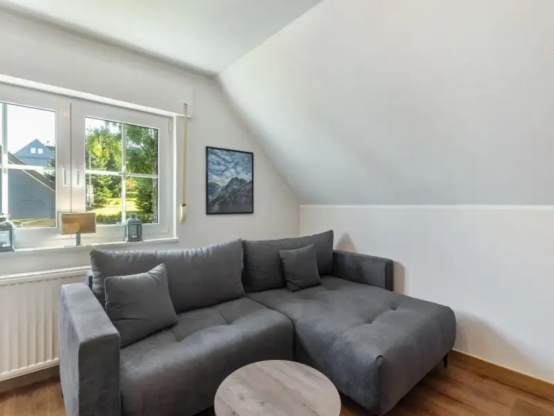 Wohnzimmer mit Sofa unter der Dachschräge, Ferienwohnung Gellinghausen