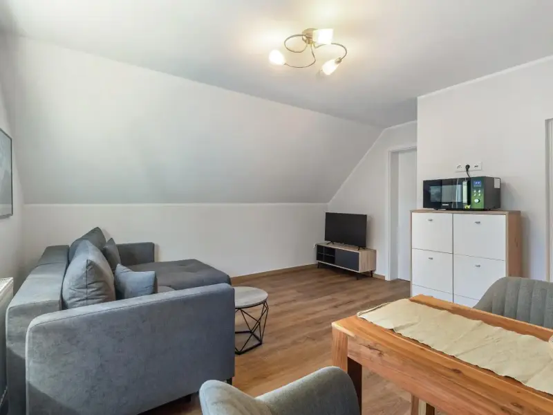 Wohnzimmer mit Sofa, Fernseher und Sideboard, Ferienwohnung Gellinghausen