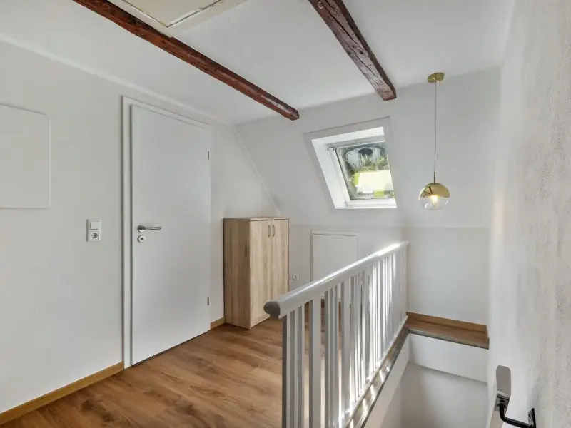 Treppenaufgang mit freiliegendem Holzbalken und Dachfenster zum Ferienwohnung Gellinghausen